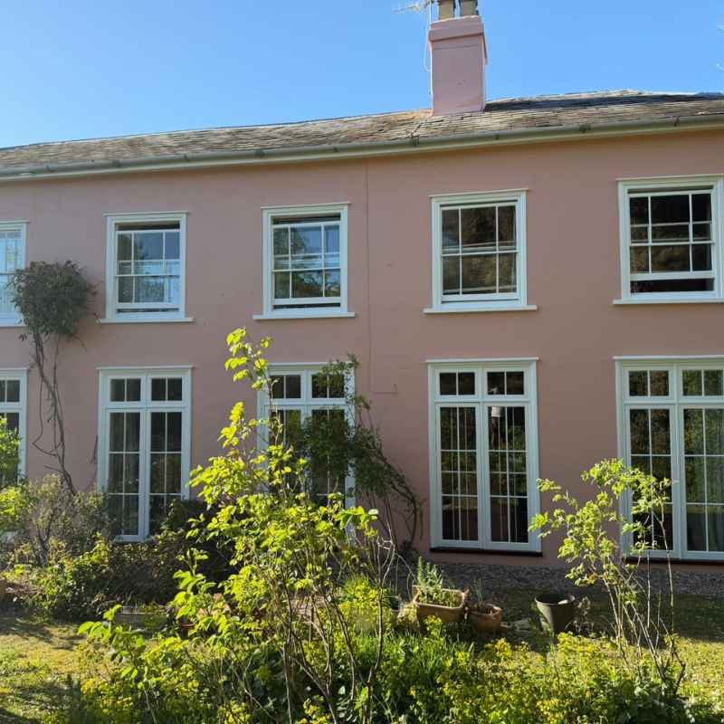 Pink house with white windows on the exterior